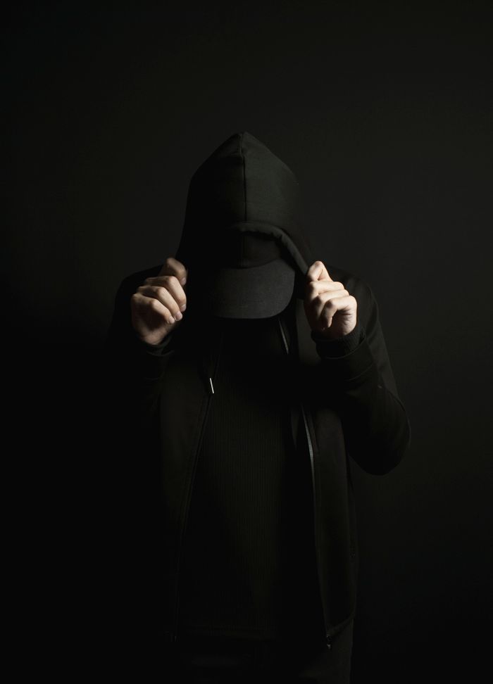 a-person-wearing-a-hoodie-in-a-dark-room-8235919